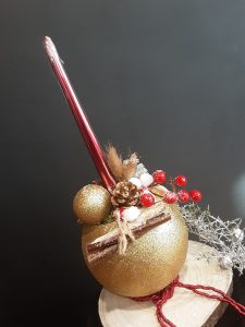 Decoración navideña en bola dorada con madera.